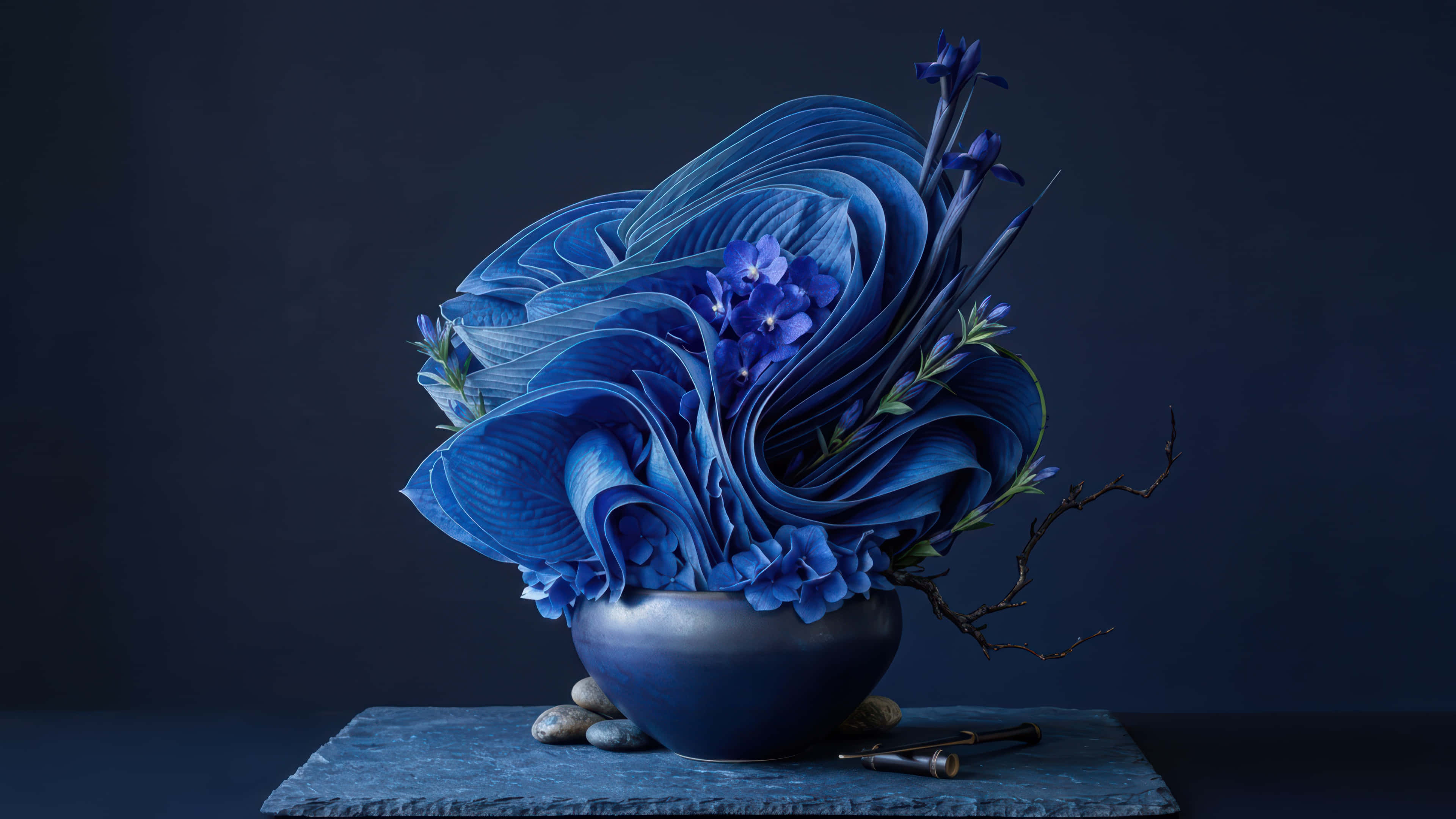 精緻 Ikebana 花藝 Bloom 桌面增強壁紙 壁紙 — 一個雕塑般的藍色花卉佈置，帶有層疊的花瓣和小花，放在深藍色碗中，置於石板托盤上，背景為深海軍藍色。