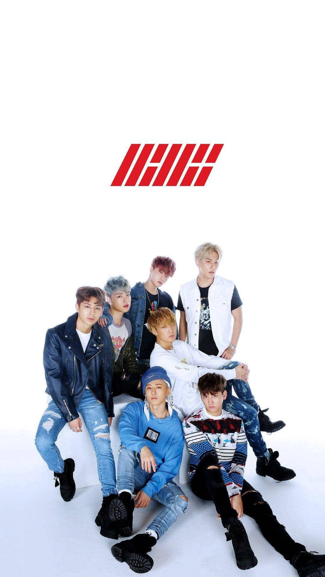 七位K-pop偶像穿著休閒服裝，在紅色標誌前拍攝工作室照片。