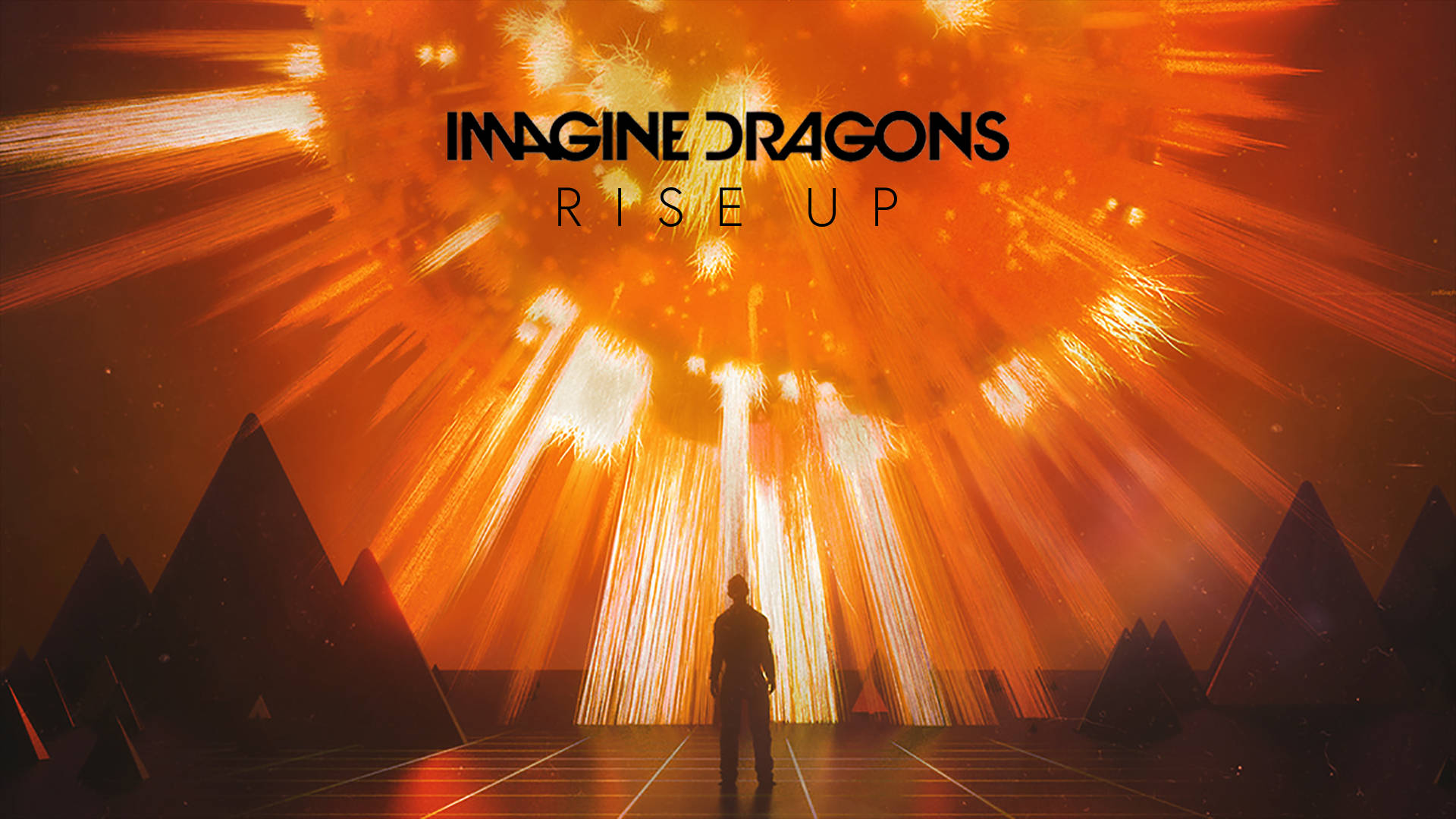 Imagine Dragons《Rise Up》宣傳海報 壁紙 — 一個孤獨的身影站在燦爛的橙色光芒爆炸前，背景有金字塔。