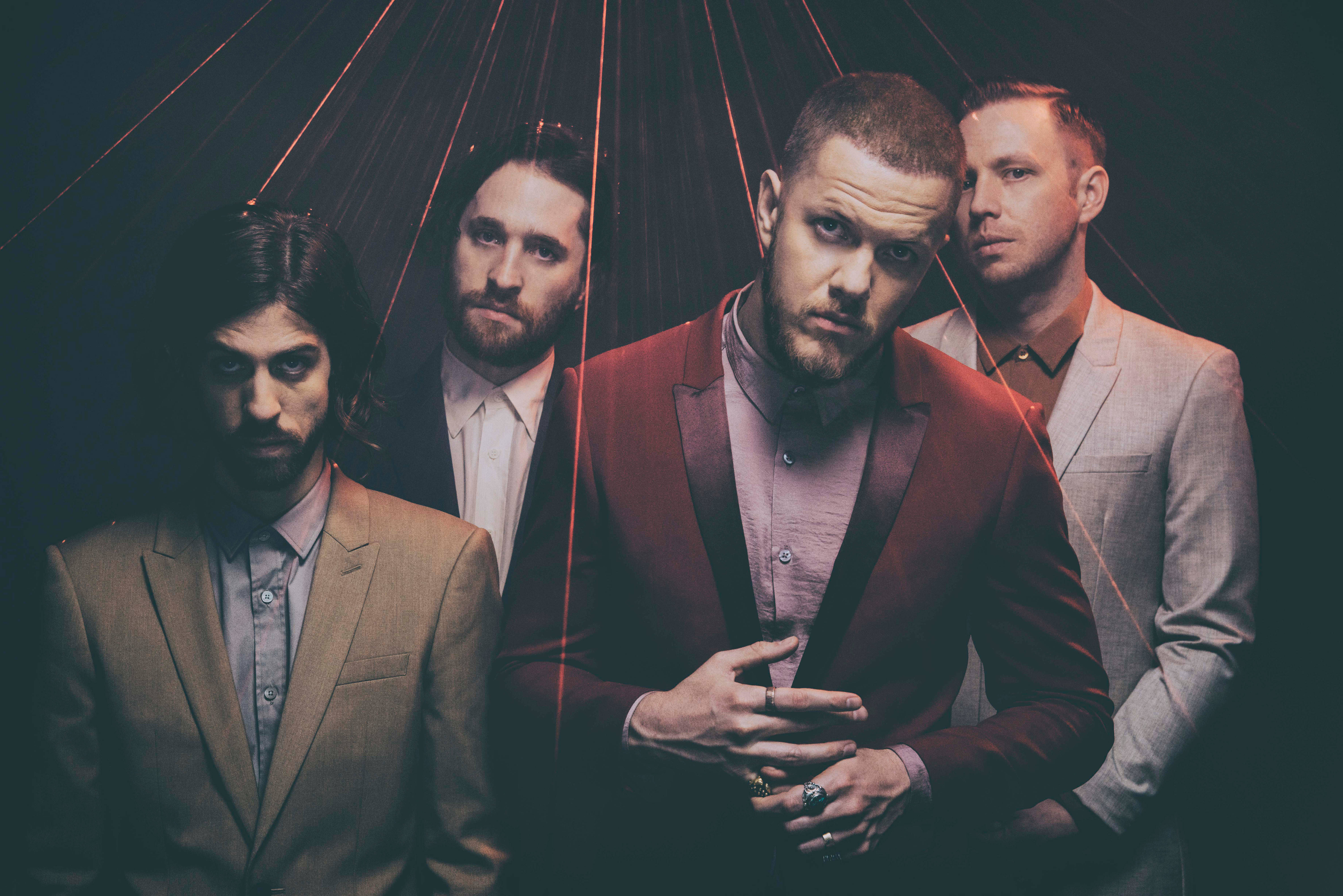 Imagine Dragons《Billboard》雜誌海報 壁紙 — 四個穿西裝的男人在黑暗背景下，於戲劇性的紅色光束下凝視。