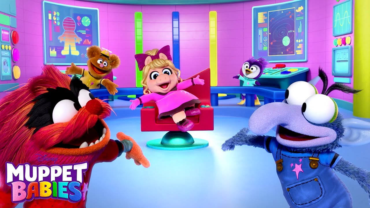 小木偶寶寶 安imal、小豬、岡佐 壁紙 — Muppet Babies 角色在充滿活力的未來實驗室中愉快互動，實驗室內有發光的屏幕和色彩繽紛的家具。