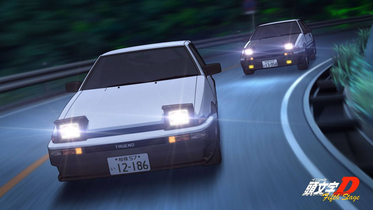兩輛賽車在彎曲的夜路上疾馳，車頭燈明亮。
