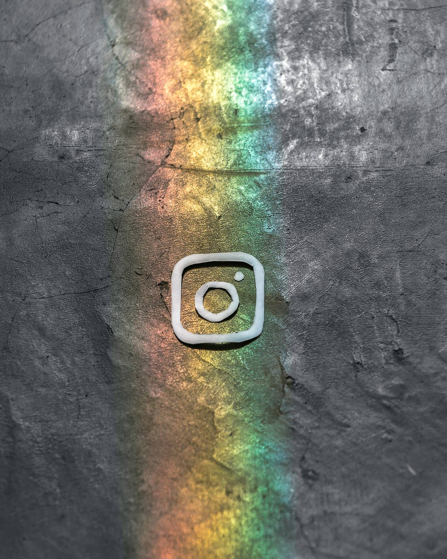Instagram標誌在破裂的混凝土上，帶有彩虹光效