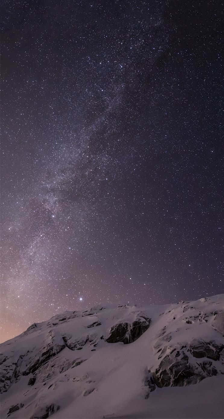 iOS 1 星光璀璨夜空 壁紙 — 積雪的山峰仰望壯麗的星空，銀河拱橋橫跨天際。