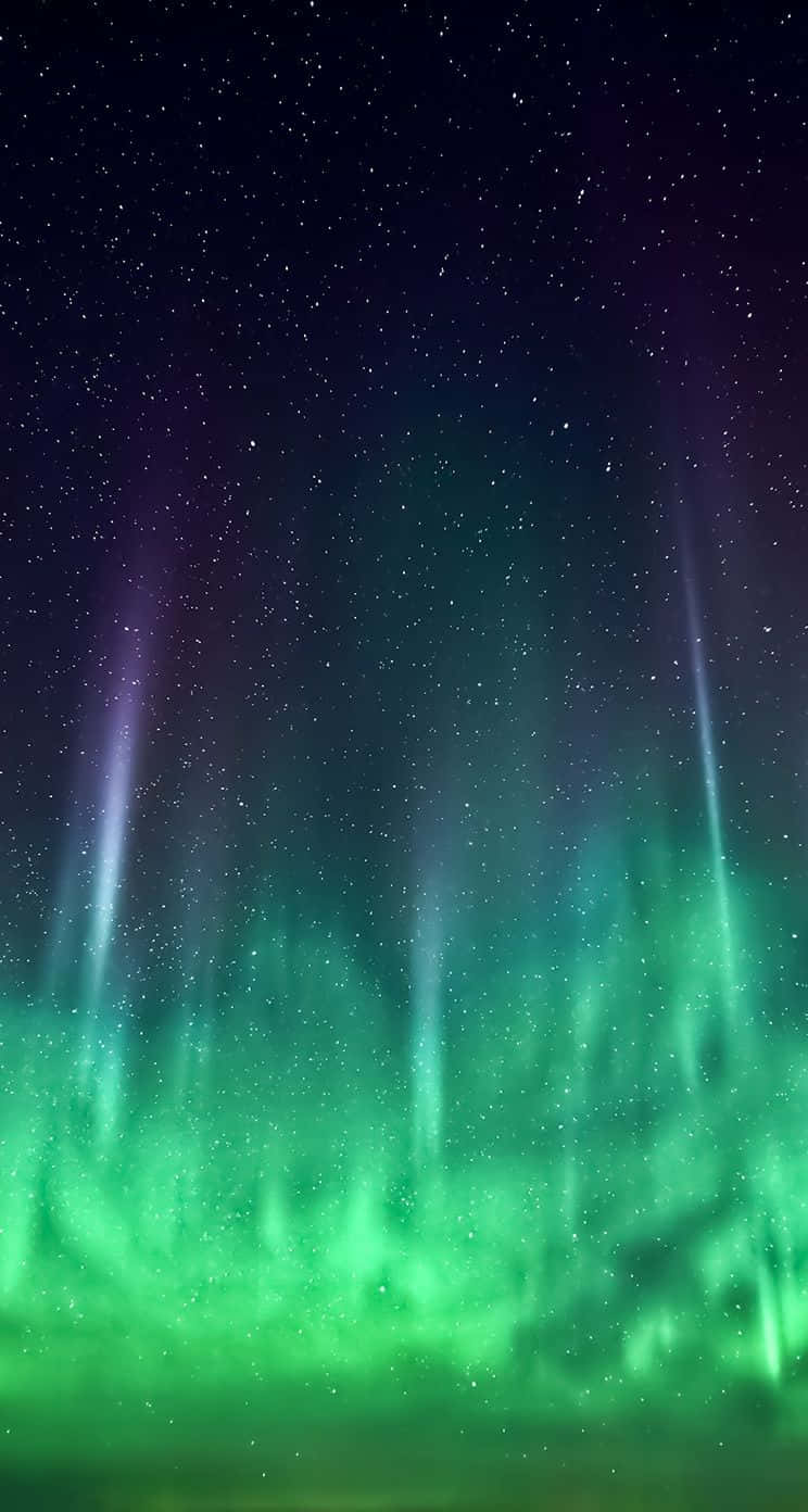 iOS 1 綠色星象天空 壁紙 — 充滿活力的綠色和紫色極光在繁星點點的夜空中舞動，垂直的光束照亮了黑暗。