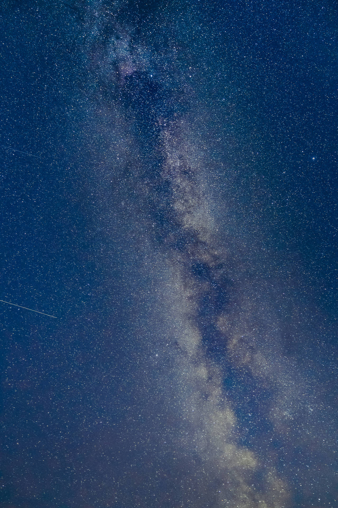 銀河系在繁星點點的夜空中閃耀，伴隨著宇宙塵埃帶。