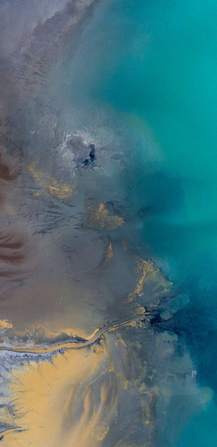俯瞰圖：碧綠湖泊毗鄰金色沙漠，蜿蜒河流與霧氣繚繞的山脈。
