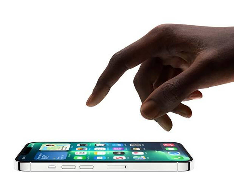 iOS 15 觸控螢幕 iPhone 壁紙 — 一隻深色皮膚的手懸浮在一部銀色智能手機上方，手機在純白背景上顯示色彩繽紛的應用程式網格。