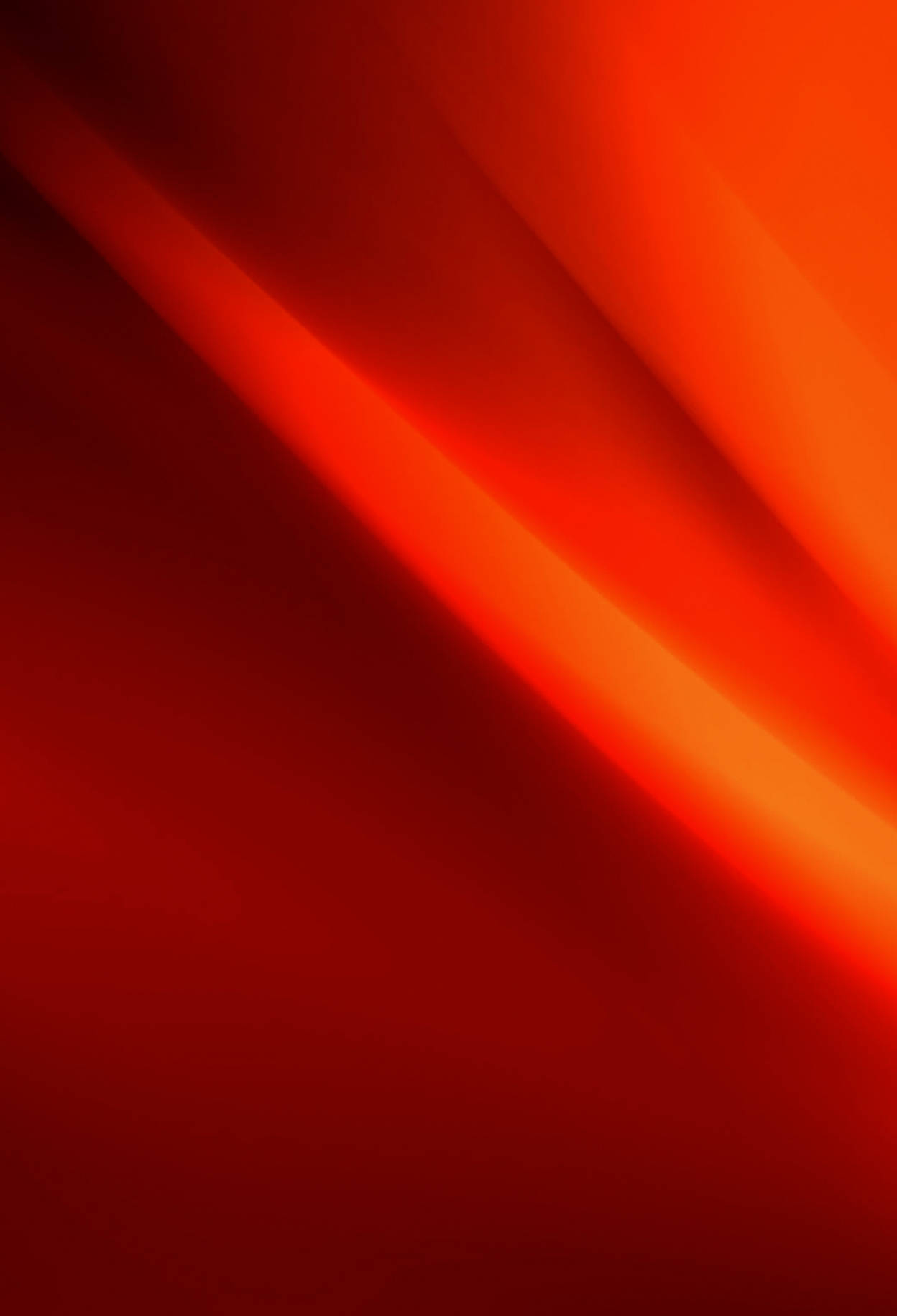 紅色紋理 iOS 16 壁紙 — 從深紅到火橙的鮮豔抽象漸變，帶有柔和對角光線條紋。