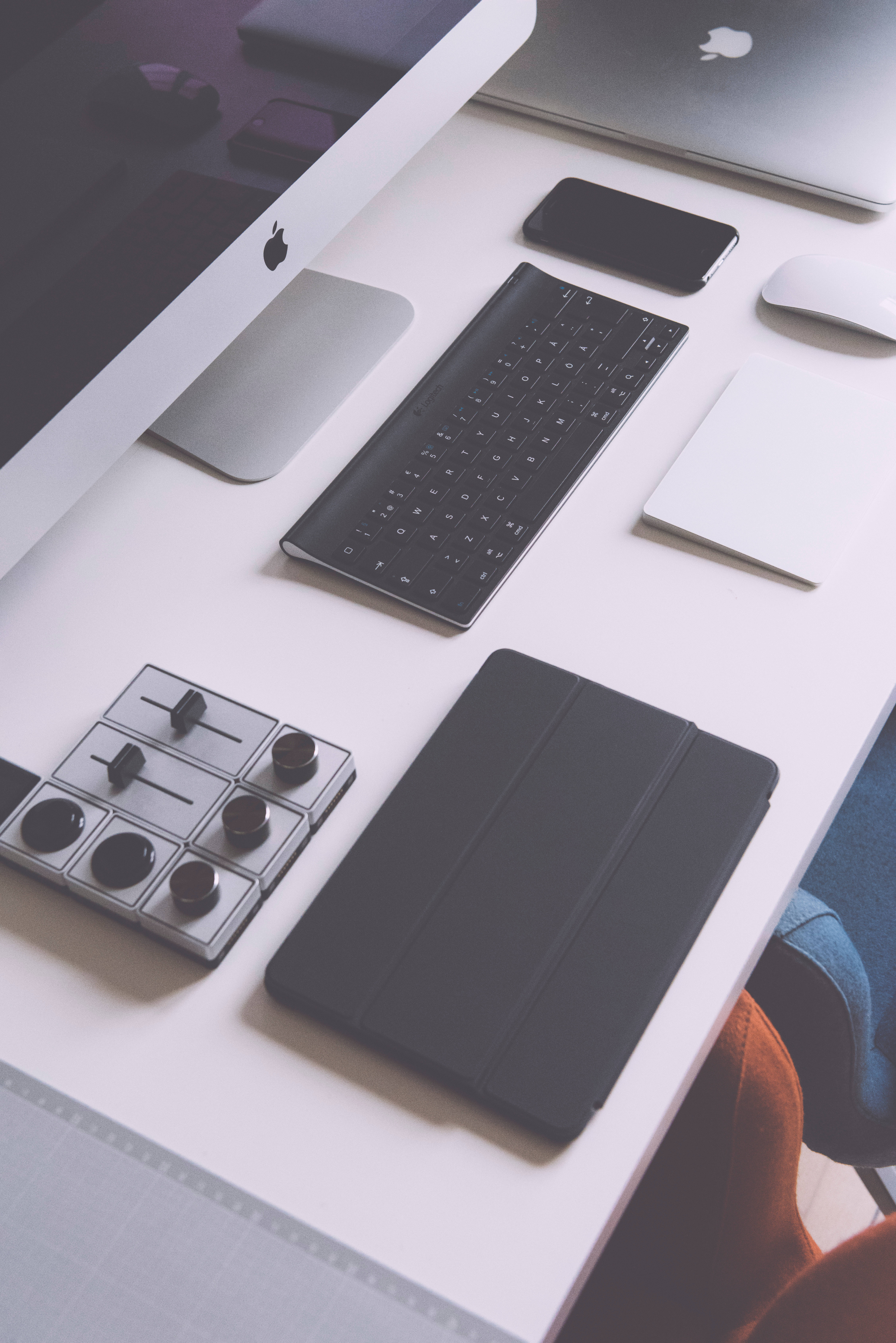創新科技——展示中的 iPad 壁紙 — 簡約白色桌面設置，配備 Apple iMac 鍵盤、滑鼠、平板電腦和控制面板，在柔和自然光下。