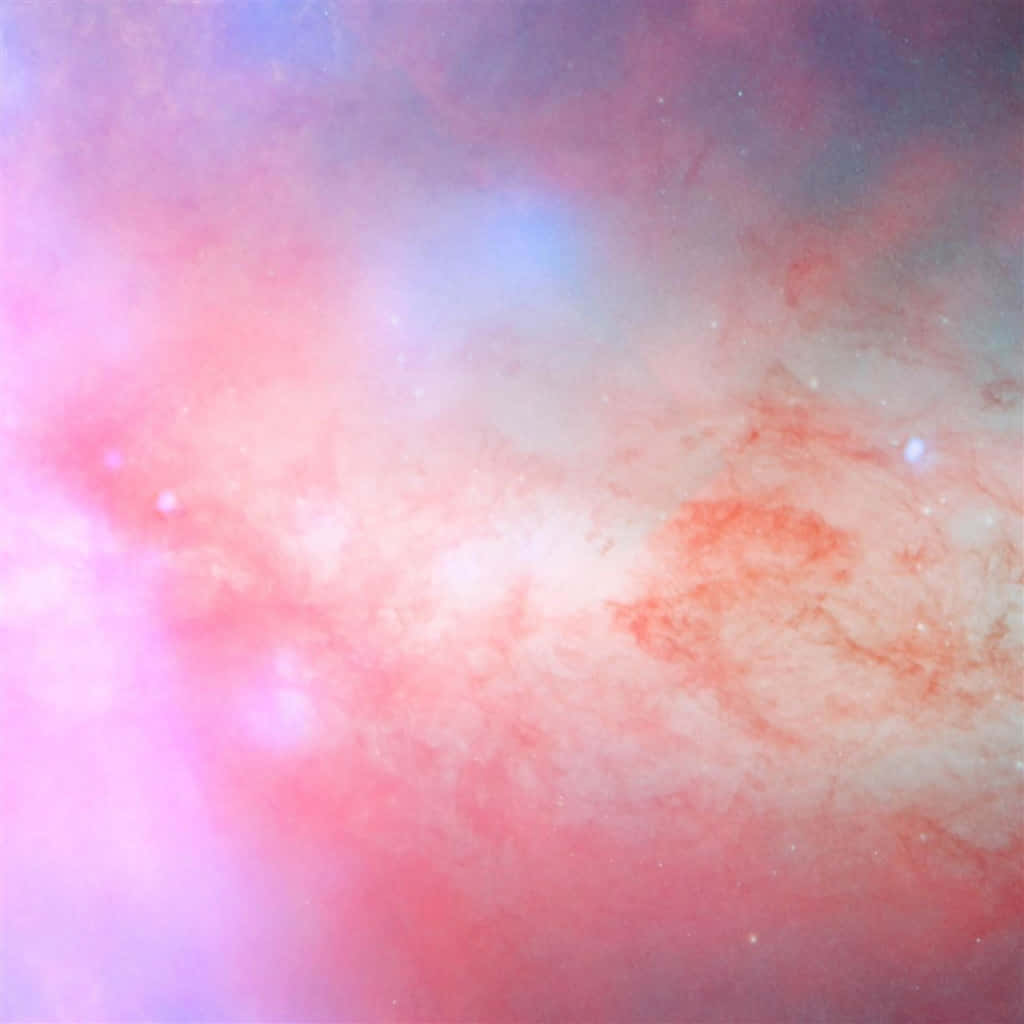 享受粉紅iPad的多彩科技 壁紙 — 宇宙星雲以柔和的粉紅、藍色和白色旋轉，散落的星星在虛空中輕輕發光。