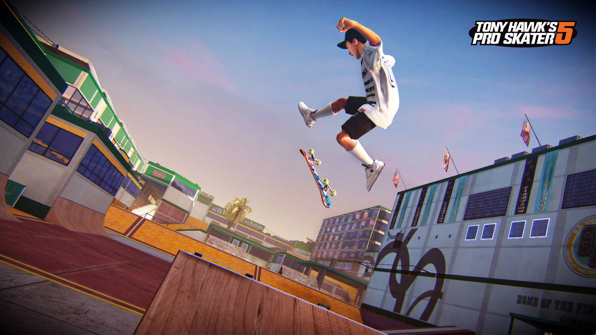 iPad Pro《Tony Hawk's Pro Skater 5》Tony Hawk空中跳躍 壁紙 — 一名滑板手在晴朗藍天下，於充滿活力的城市滑板公園的木製坡道上騰空飛翔。