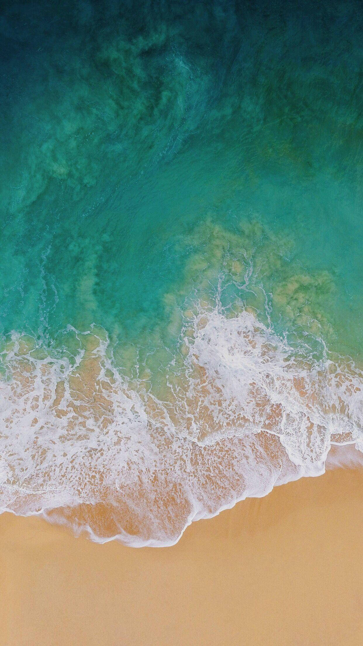 iPad Pro 海岸波浪鳥瞰圖 壁紙 — 從空中俯瞰，在寧靜的海岸景色中，碧綠的海浪拍打著金色的沙灘。