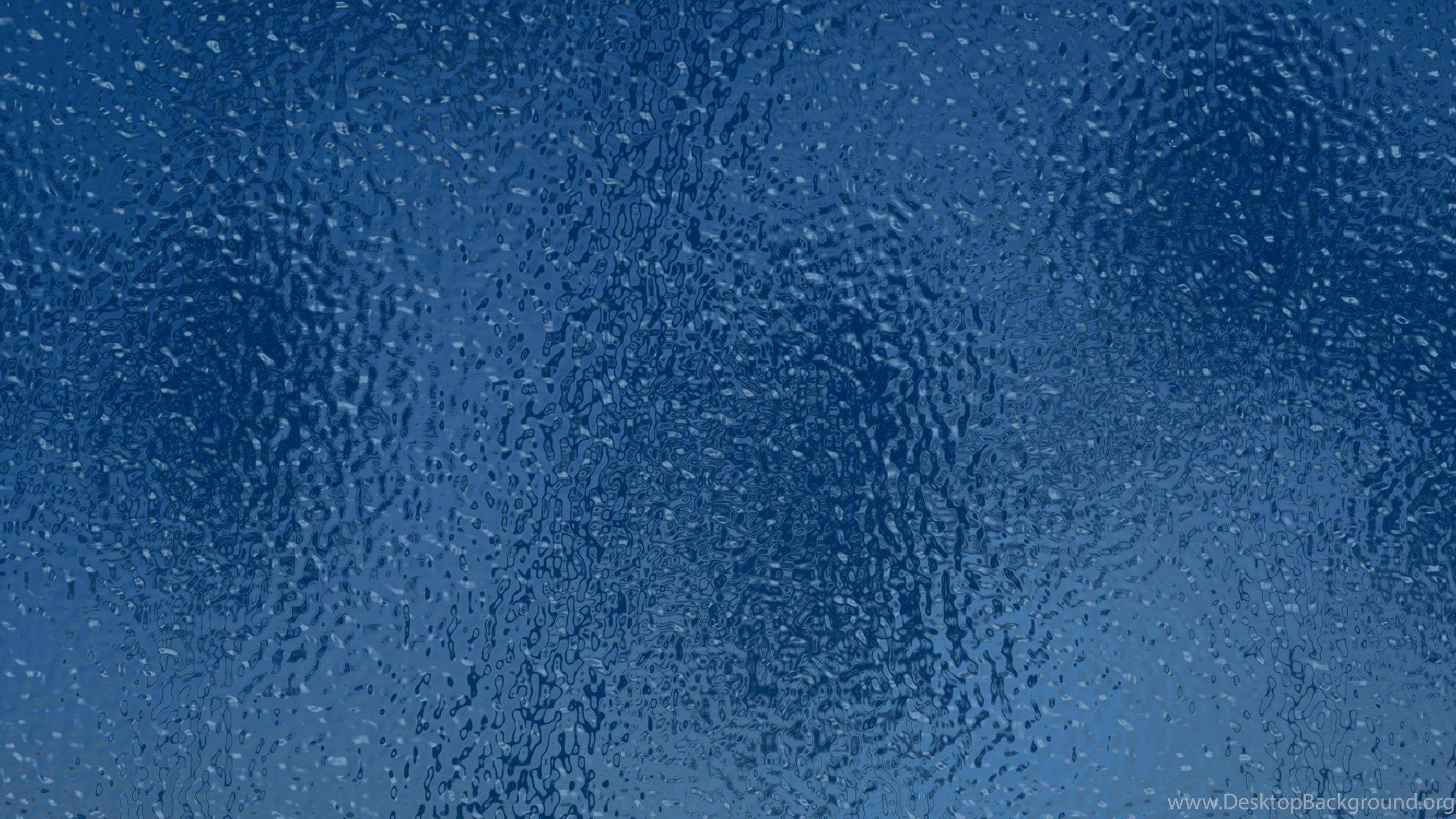 iPad Pro 海浪鳥瞰 壁紙 — 雨滴依附在清涼藍色玻璃表面上的特寫，形成帶紋理的水紋圖案。