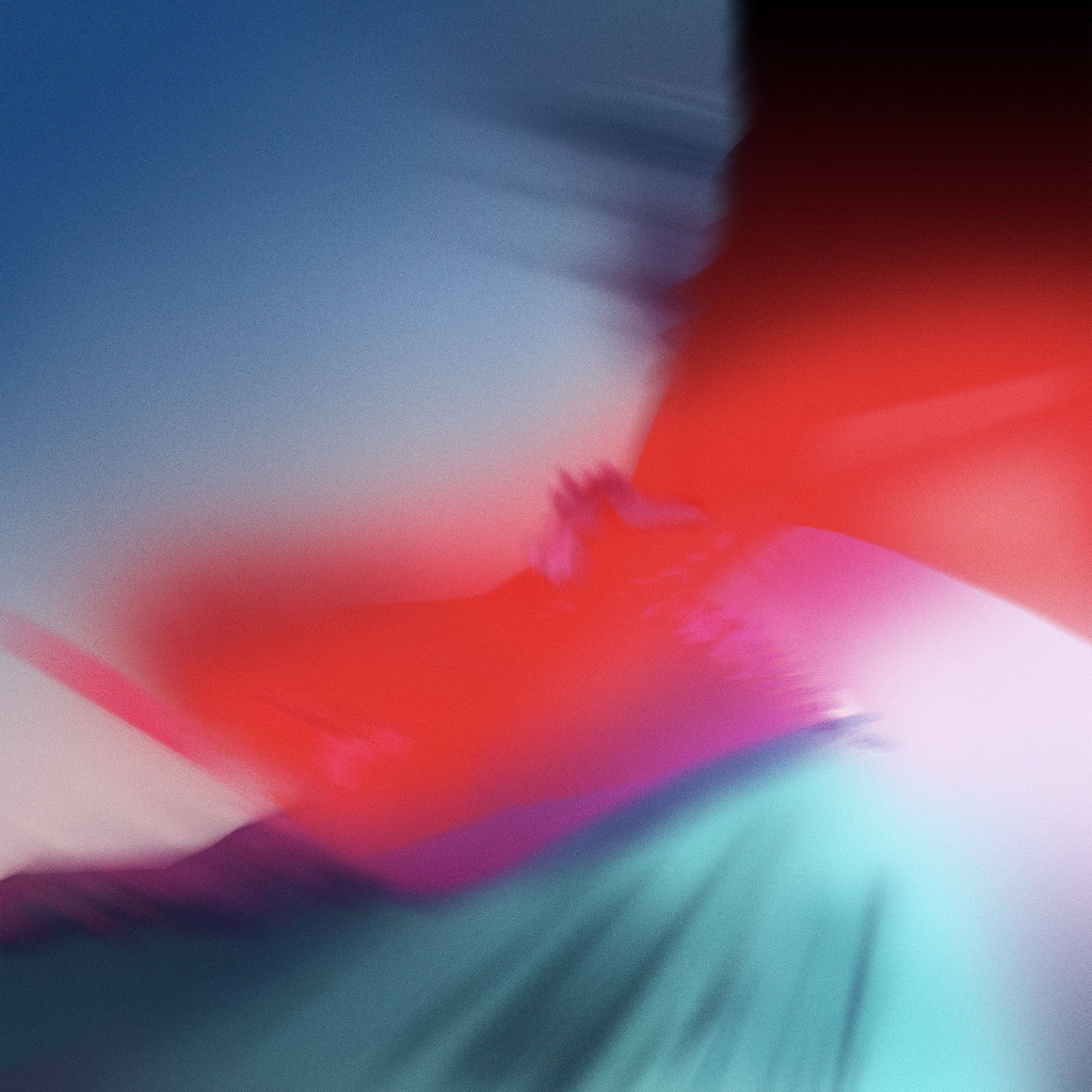 iPad Pro夜色紅藍模糊色塊 壁紙 — 充滿活力的抽象動態模糊，旋轉的紅色、藍色和藍綠色調營造出動態流體效果。