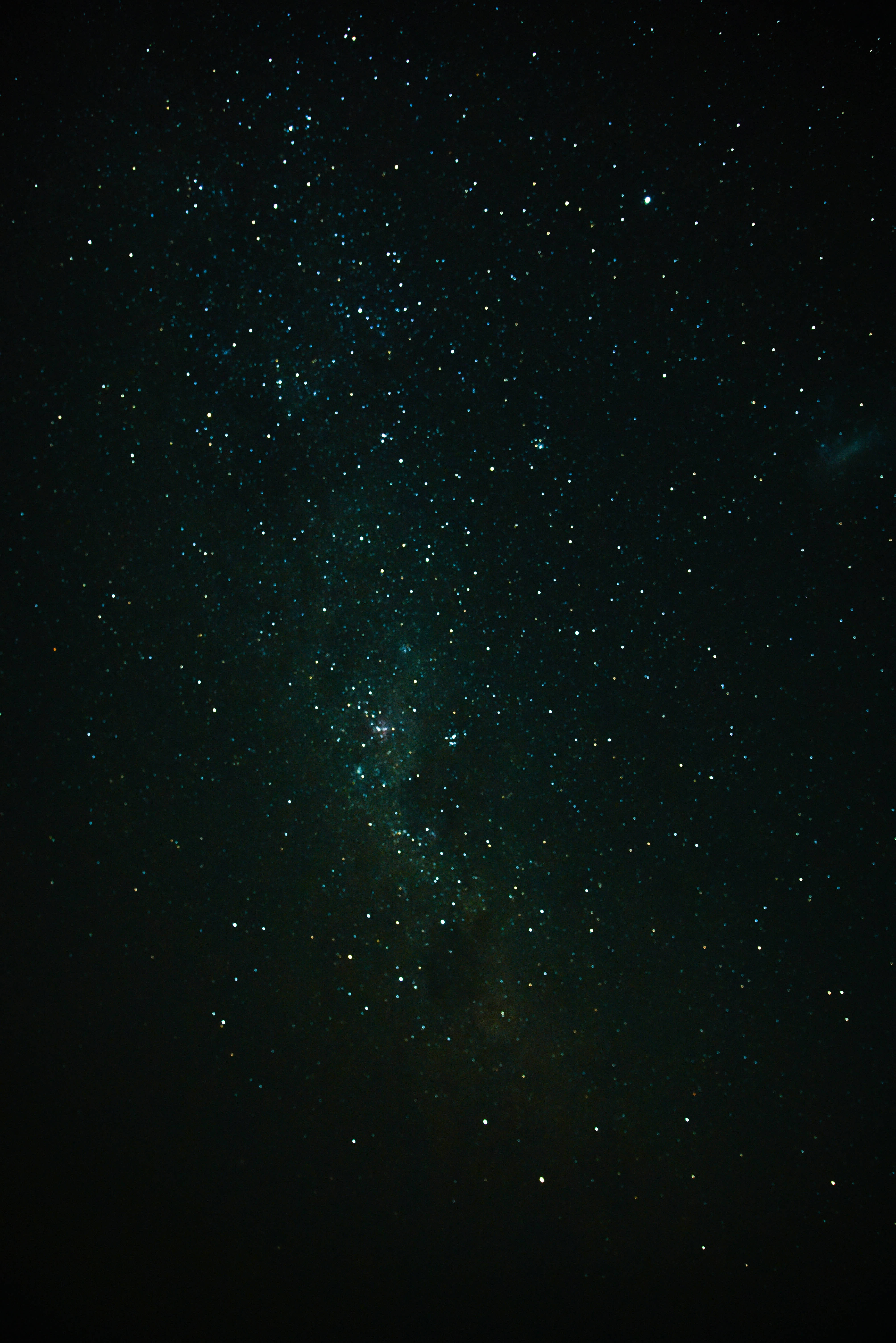iPhone 11 黑色夜空 壁紙 — 令人嘆為觀止的銀河系景觀，在深邃的黑色夜空中閃爍著青綠色和白色的星星。
