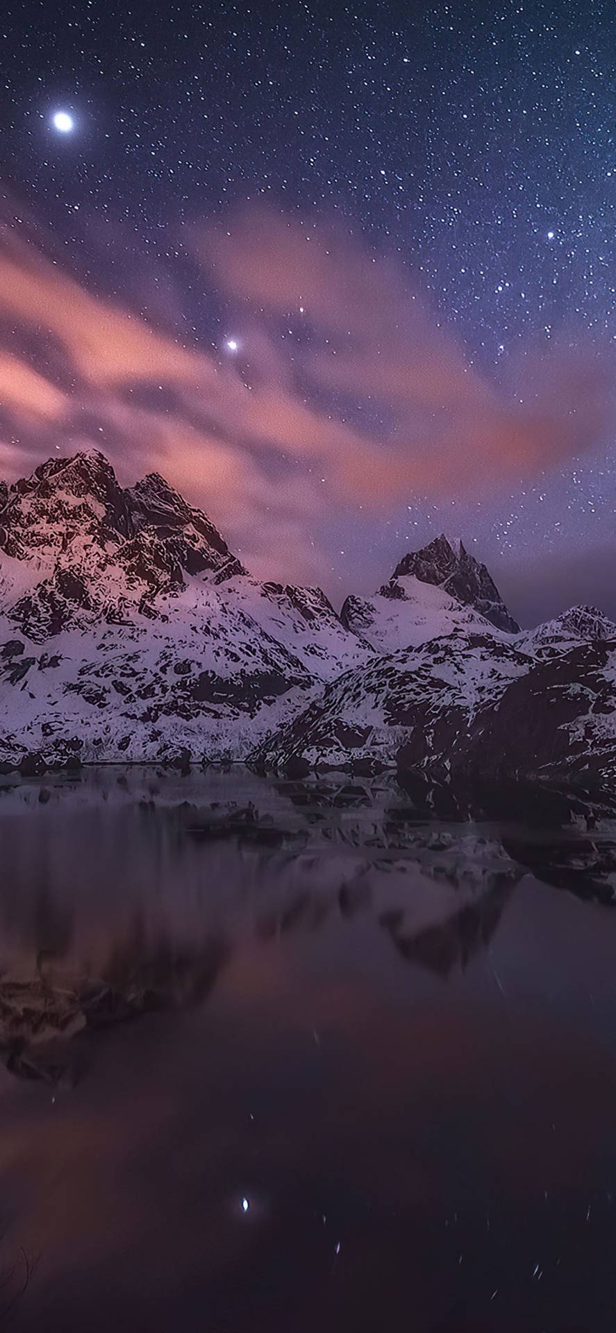 積雪的山脈在星空下倒映在平靜的水面，粉紅和紫色的夜空。