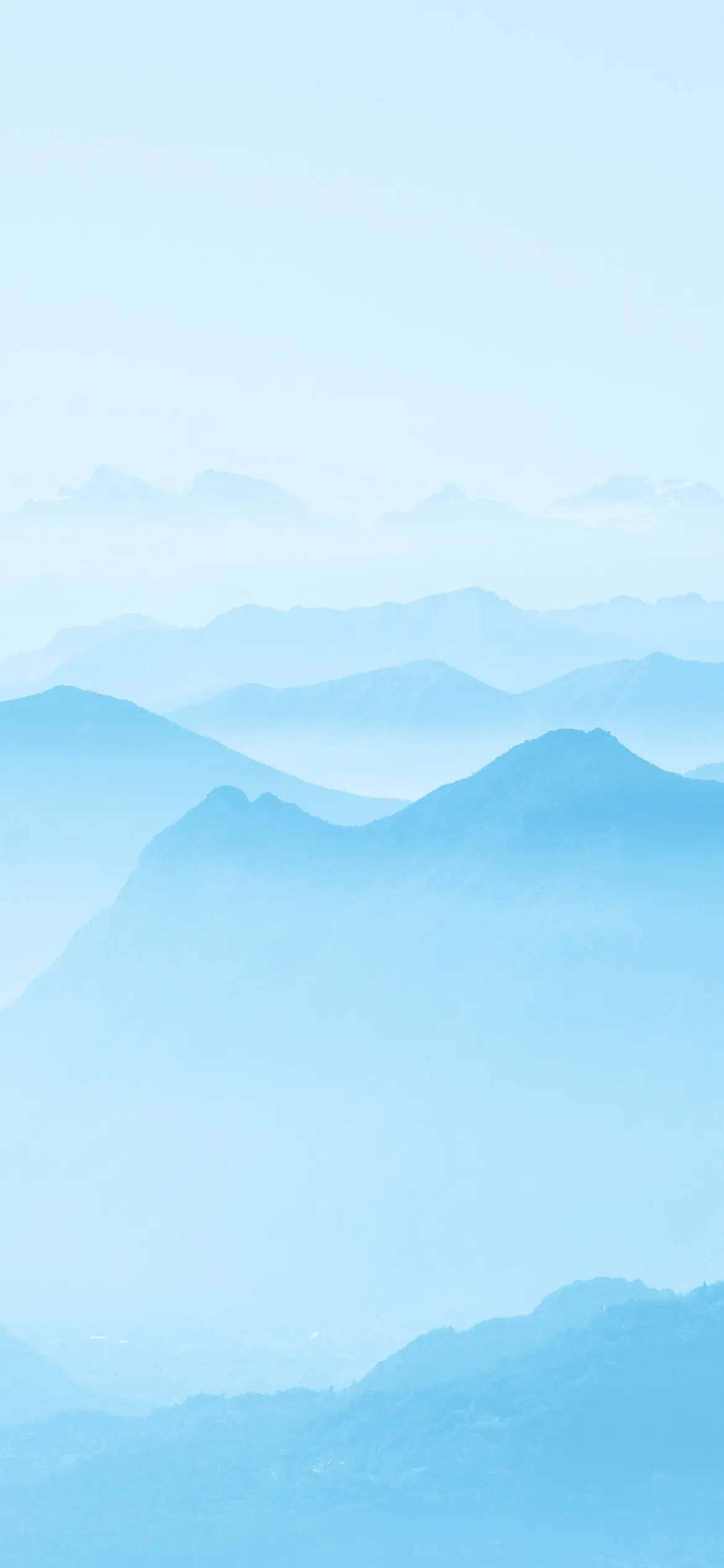山景淺藍色美學iPhone壁紙 壁紙 — 寧靜的層疊山脈在柔和天空下逐漸消失在迷濛的藍色薄霧中。