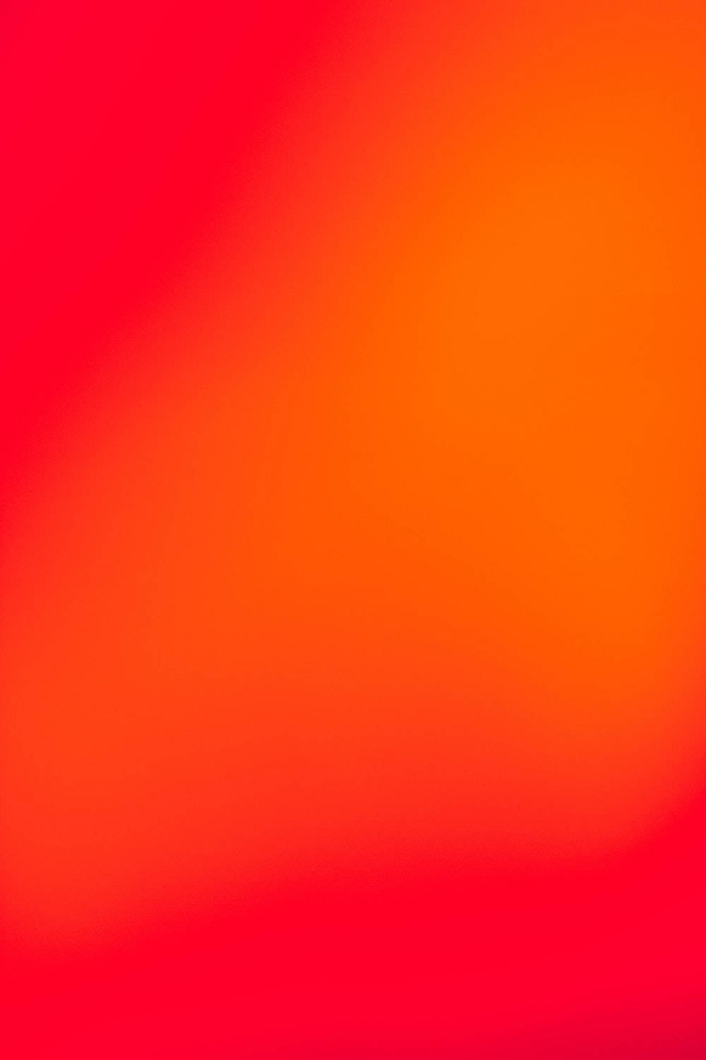 粉與橙雙色iPhone壁紙 壁紙 — 從火紅到暖橙的平滑漸變，以發光、抽象的溫暖填滿畫面。
