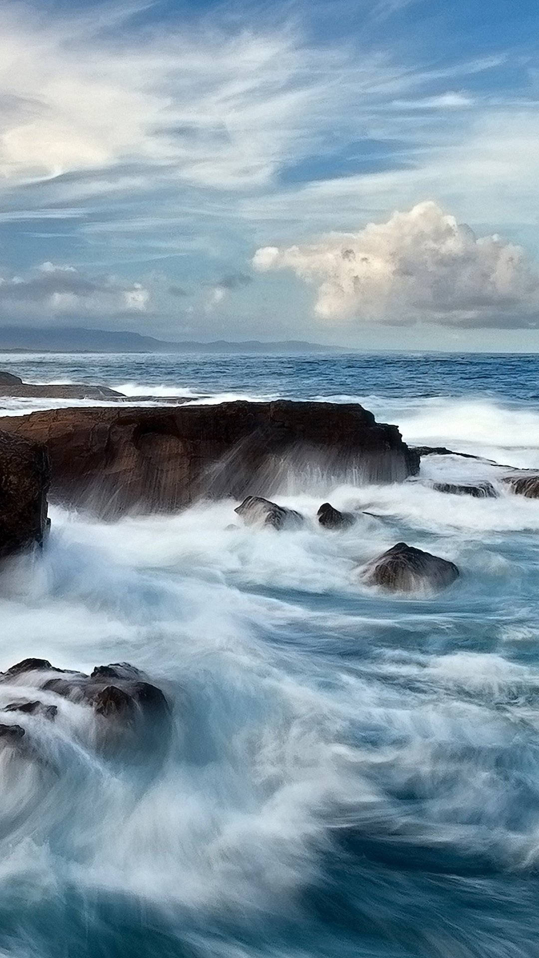 海浪在陰天下拍打著黑暗的岩石