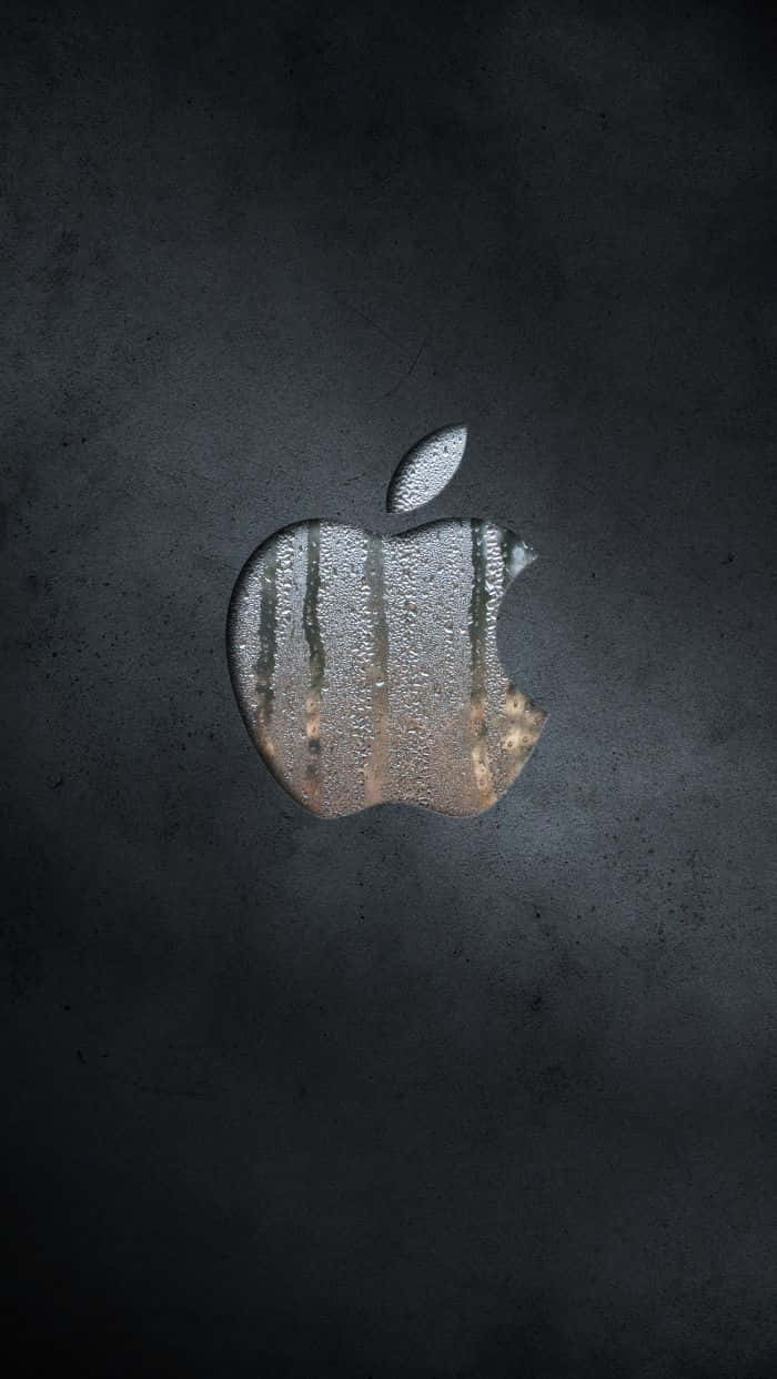 升級至最佳 iPhone 7 Plus 壁紙 — 一個帶有水珠的風化金屬蘋果標誌，放置在深色紋理表面上。