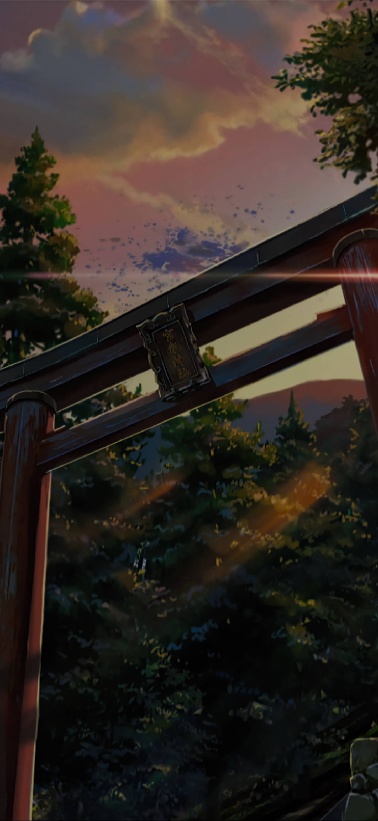 你的名字 iPhone 神社鳥居夕照 壁紙 — 一座木製鳥居框住了日落時分的森林，上方有粉紅色和橙色的雲彩。