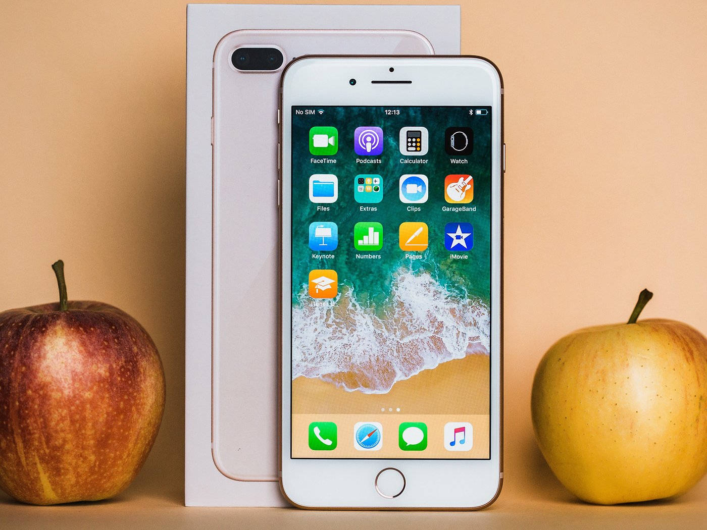 白色iPhone 8 Plus，Apple標誌盒子，米色表面上兩個真蘋果。