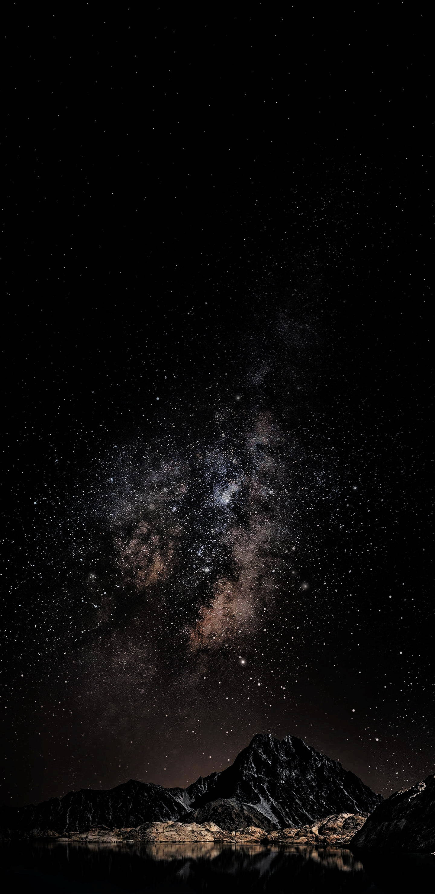 暗山星際iPhone壁紙 壁紙 — 令人嘆為觀止的夜空，佈滿無數星辰，銀河在平靜水面倒映的黑暗山脈上空拱起。