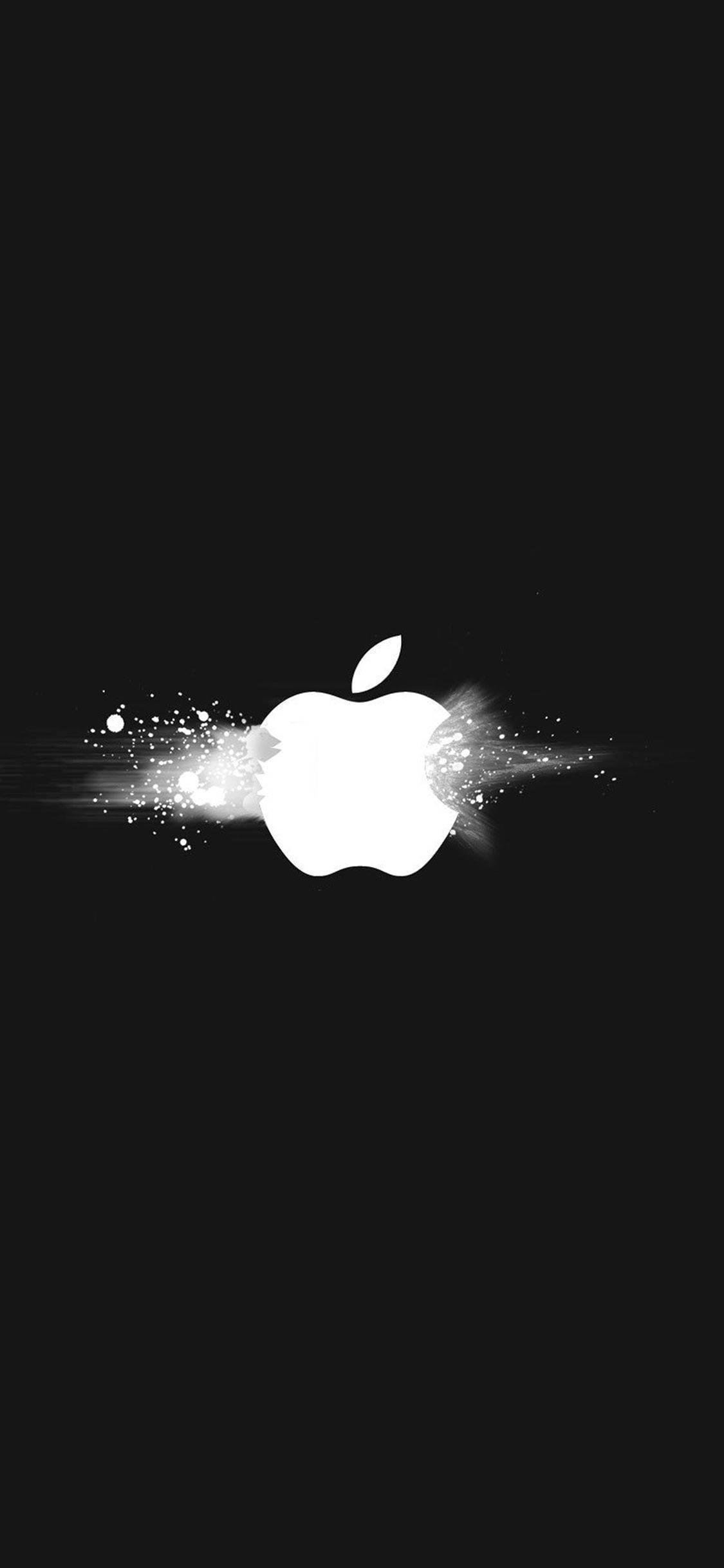 iPhone Apple標誌 爆炸效果 壁紙 — 發光的白色Apple標誌在純黑背景上迸發出閃爍的粒子。