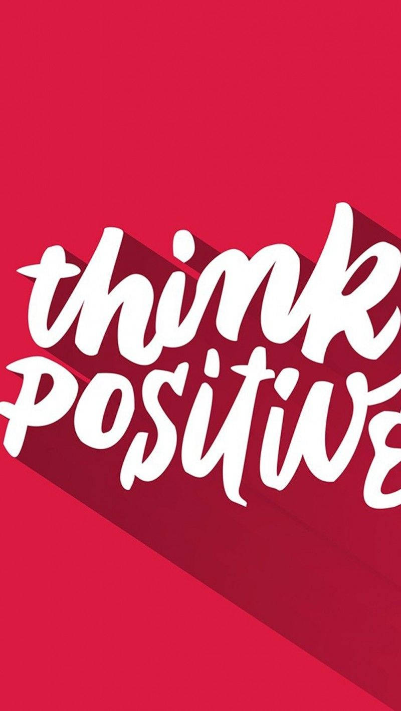 正面勵志語 iPhone 壁紙 — 粗體白色草書文字寫著 think positive，在鮮紅色背景上投下長長的陰影。
