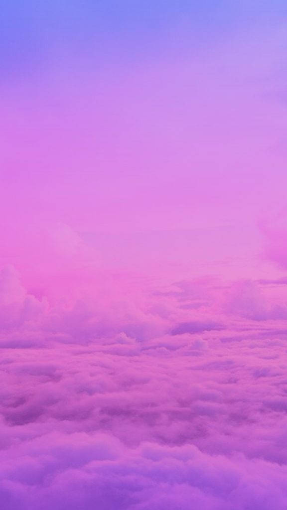 粉紅雲朵原版 iPhone 壁紙 — 從高空俯瞰 fluffy 雲朵，沐浴在柔和粉紅與紫色暮光中的夢幻景象。