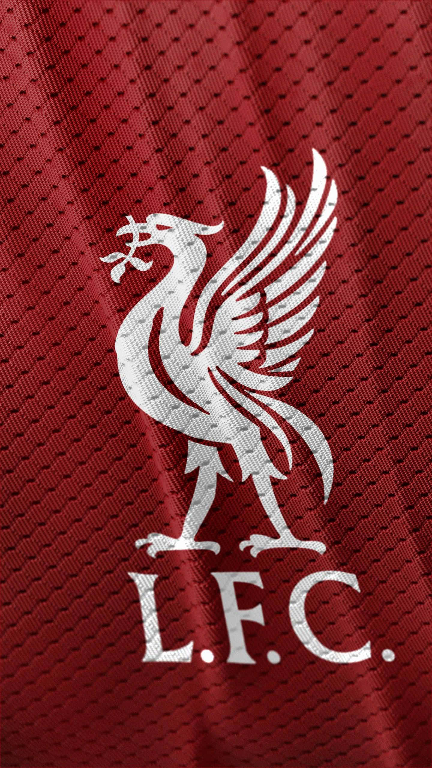 以 iPhone 展現利物浦風采 壁紙 — 白色Liverbird標誌，帶有L.F.C.文字，位於紋理紅色運動球衣布料上。