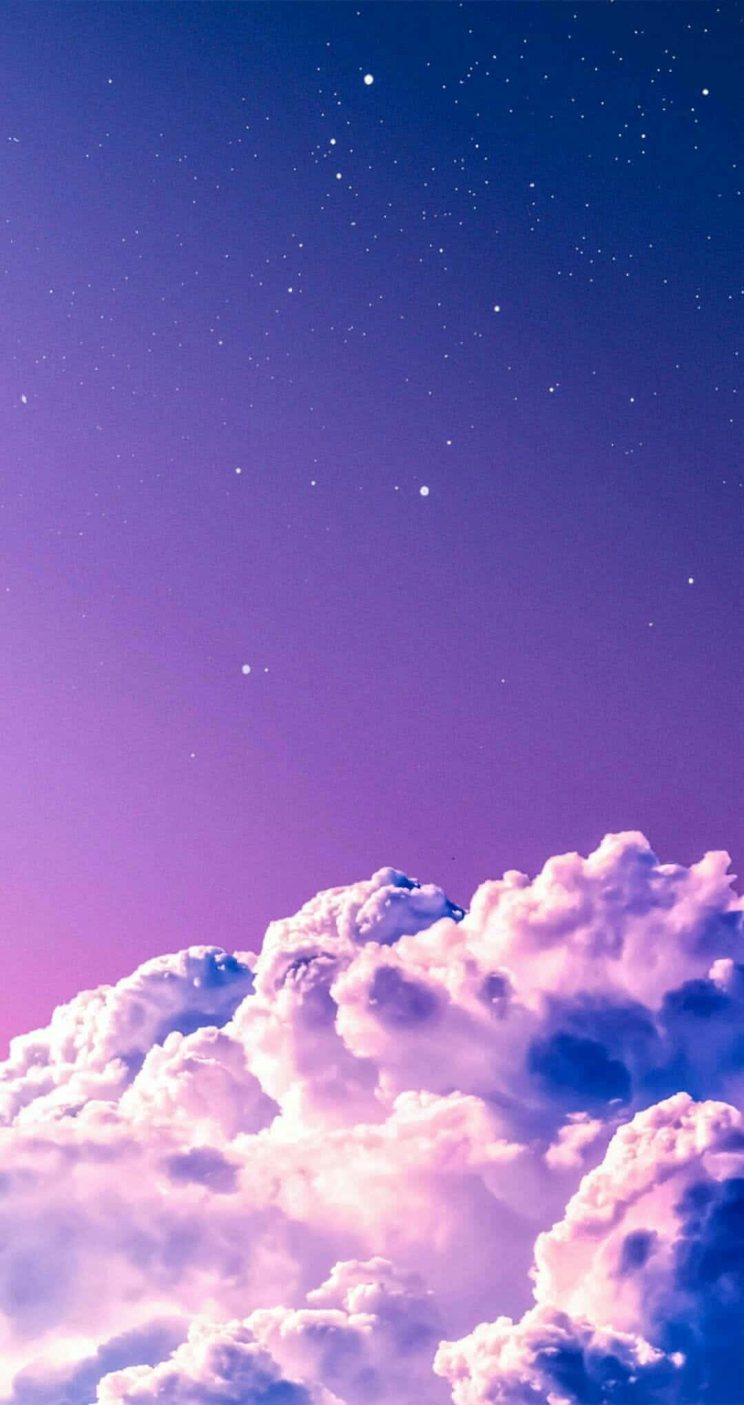 iPhone薰衣草風厚雲 壁紙 — 廣闊的紫色和藍色天空，佈滿星星，在粉紅色和薰衣草色調中閃爍的蓬鬆雲朵之上。