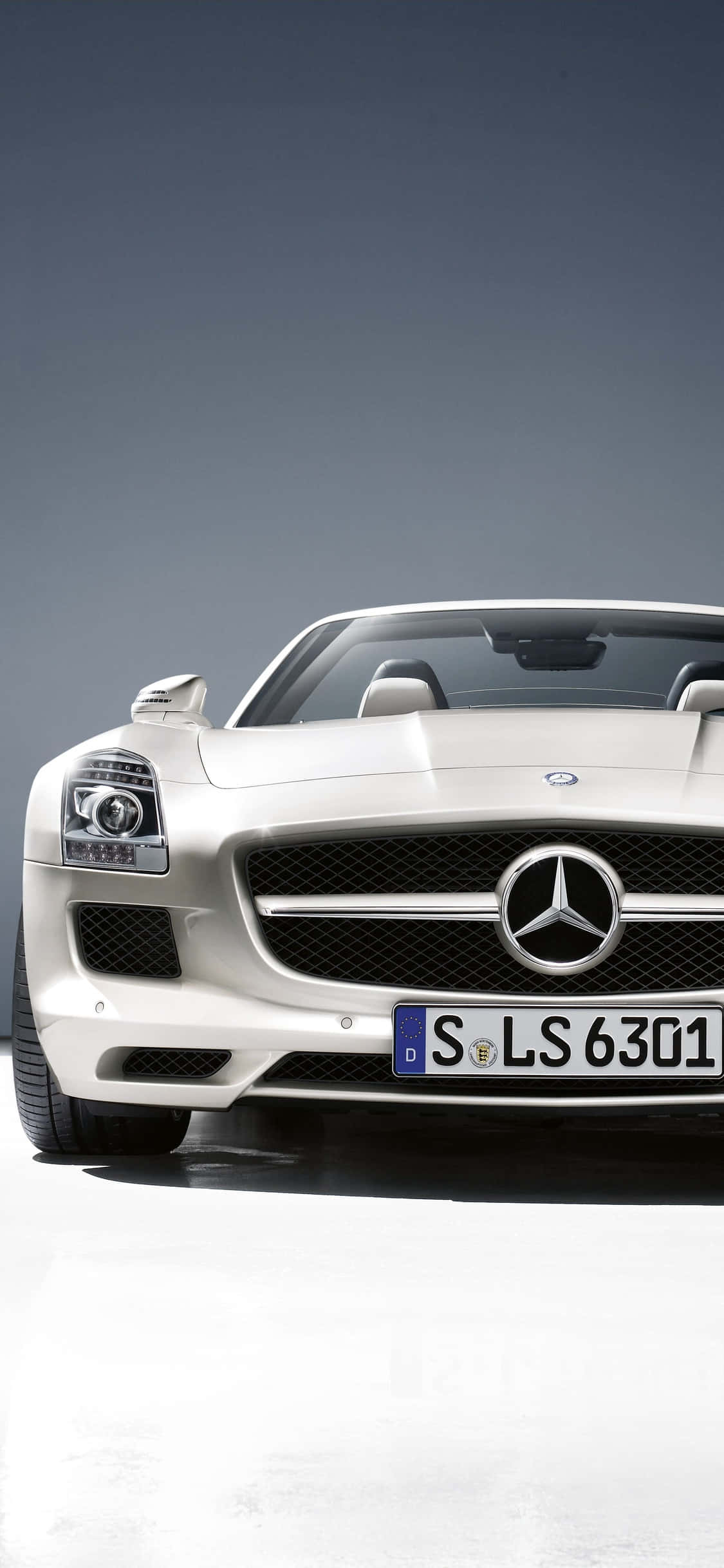 iPhone X AMG GT-R 背景白色 SLS AMG 壁紙 — 一輛時尚的白色Mercedes SLS AMG跑車在漸變灰色背景的攝影棚中展示。