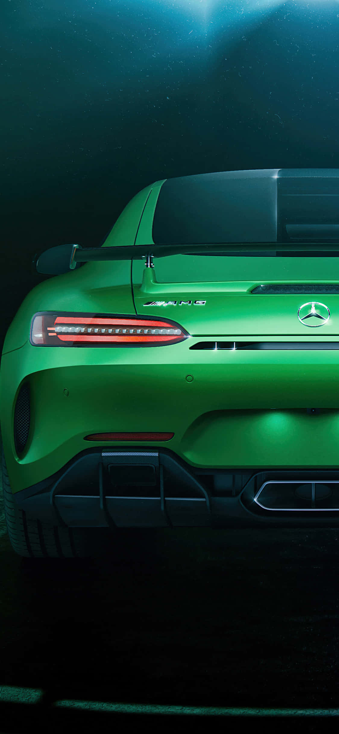 iPhone X AMG GT-R 背景尾燈 AMG GT 壁紙 — 一輛充滿活力的綠色Mercedes-AMG跑車尾部在戲劇性的水下燈光下閃耀著紅色尾燈。