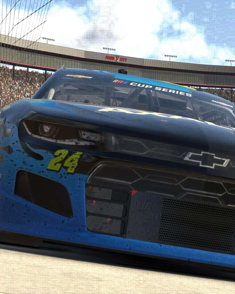 iPhone X《Dirt Showdown》雪佛蘭科邁羅背景 壁紙 — 藍色NASCAR盃系列賽車24號在明亮天空下於賽道上疾馳的特寫。