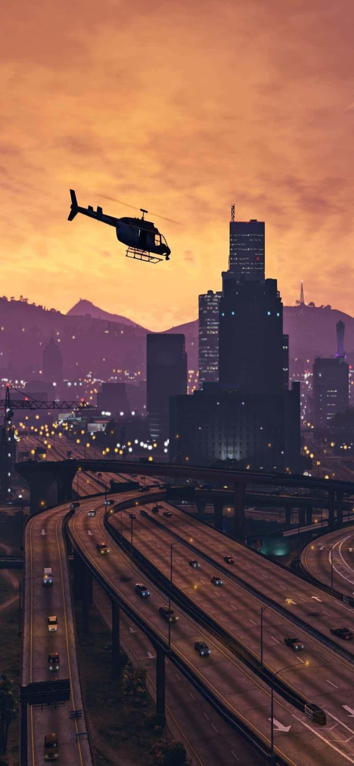 iPhone X《GTA V》城市直升機背景 壁紙 — 一架直升機在日落時分飛越廣闊的城市景觀，有發光的高速公路和高聳的摩天大樓。