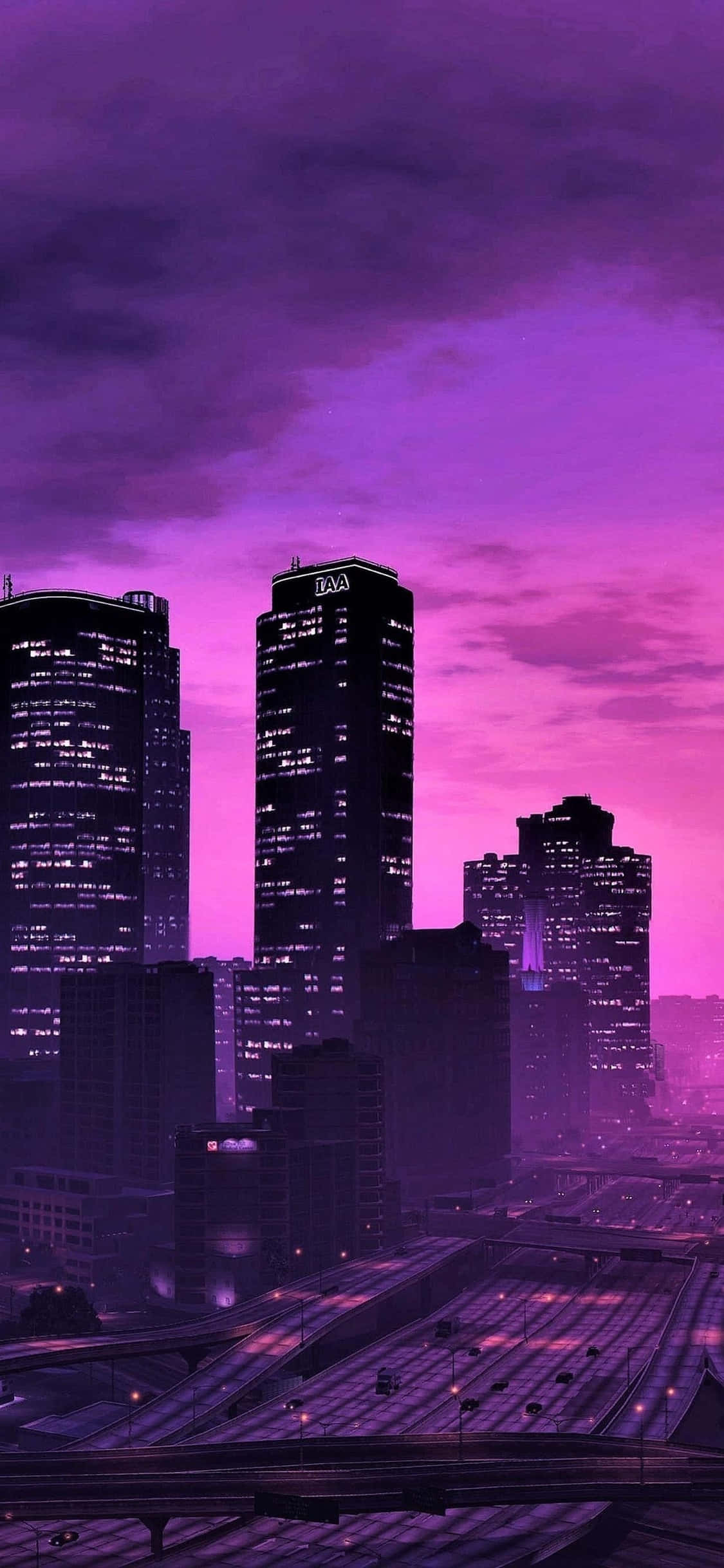 iPhone X《GTA V》夜城背景 壁紙 — 黃昏時分的未來城市天際線，沐浴在充滿活力的紫色和粉紅色調中，閃爍的摩天大樓和明亮的公路。