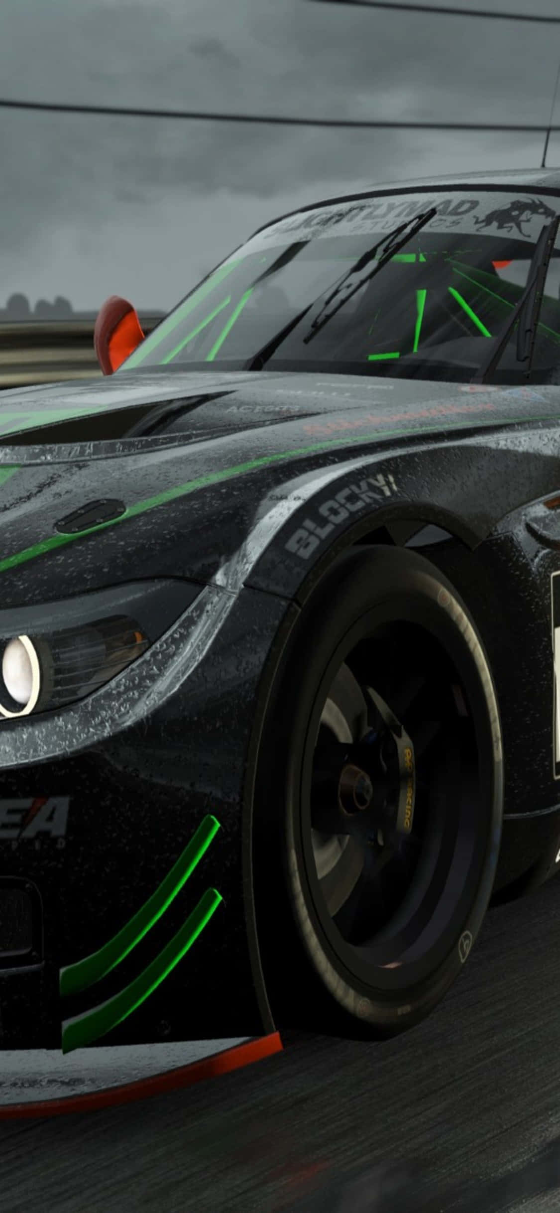iPhone X《Project Cars》亮黑 BMW Z4 GT3 (E89) 背景 壁紙 — 一架時尚的黑色賽車帶有發光的綠色點綴，在暴風雨灰暗的天空下於潮濕的賽道上疾馳。