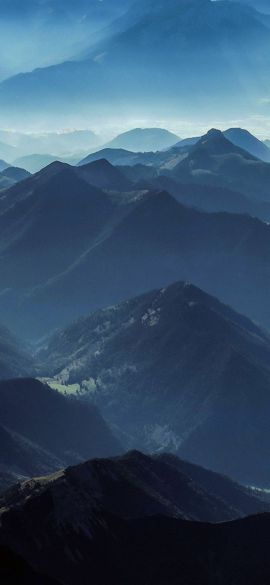 在柔和藍色晨霧中，層巒疊嶂的寧靜山脈。