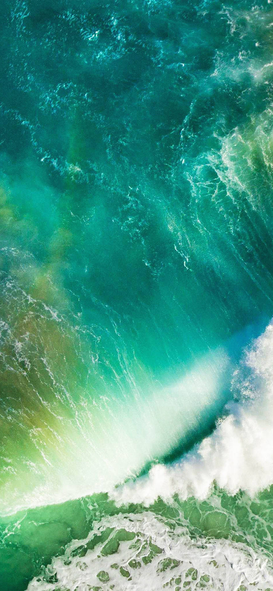 強勁的海浪拍打著充滿活力的綠色海床，激起白色泡沫。