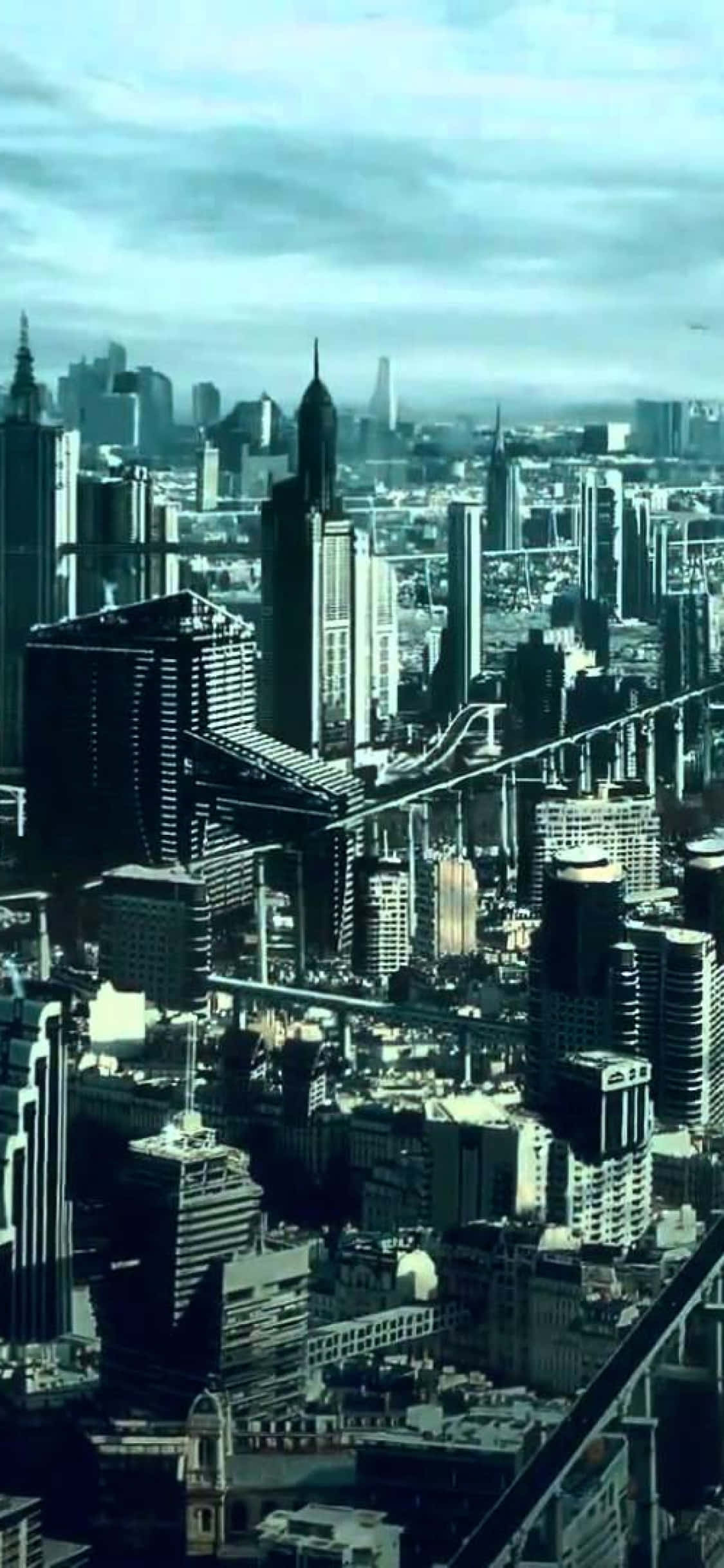 iPhone X《地球之外文明》背景：暗色建築 壁紙 — 從高角度俯瞰一個密集的未來城市景觀，高聳的摩天大樓在陰天之下。
