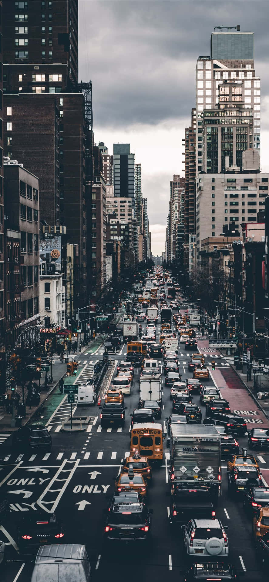 繁忙的城市街道，充滿汽車和高樓大廈，天空多雲。