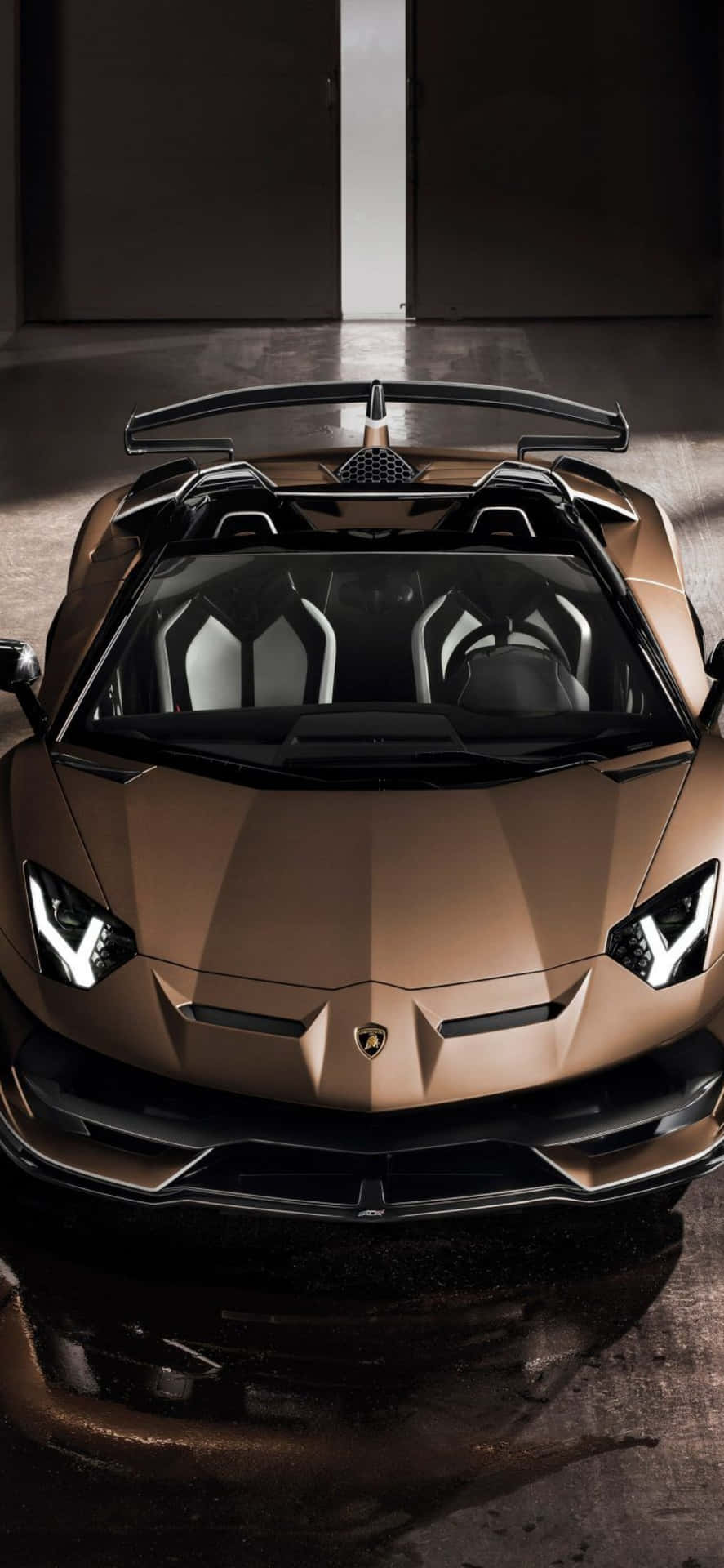 青銅色林寶堅尼Aventador Roadster在黑暗車庫中，帶有戲劇性燈光。