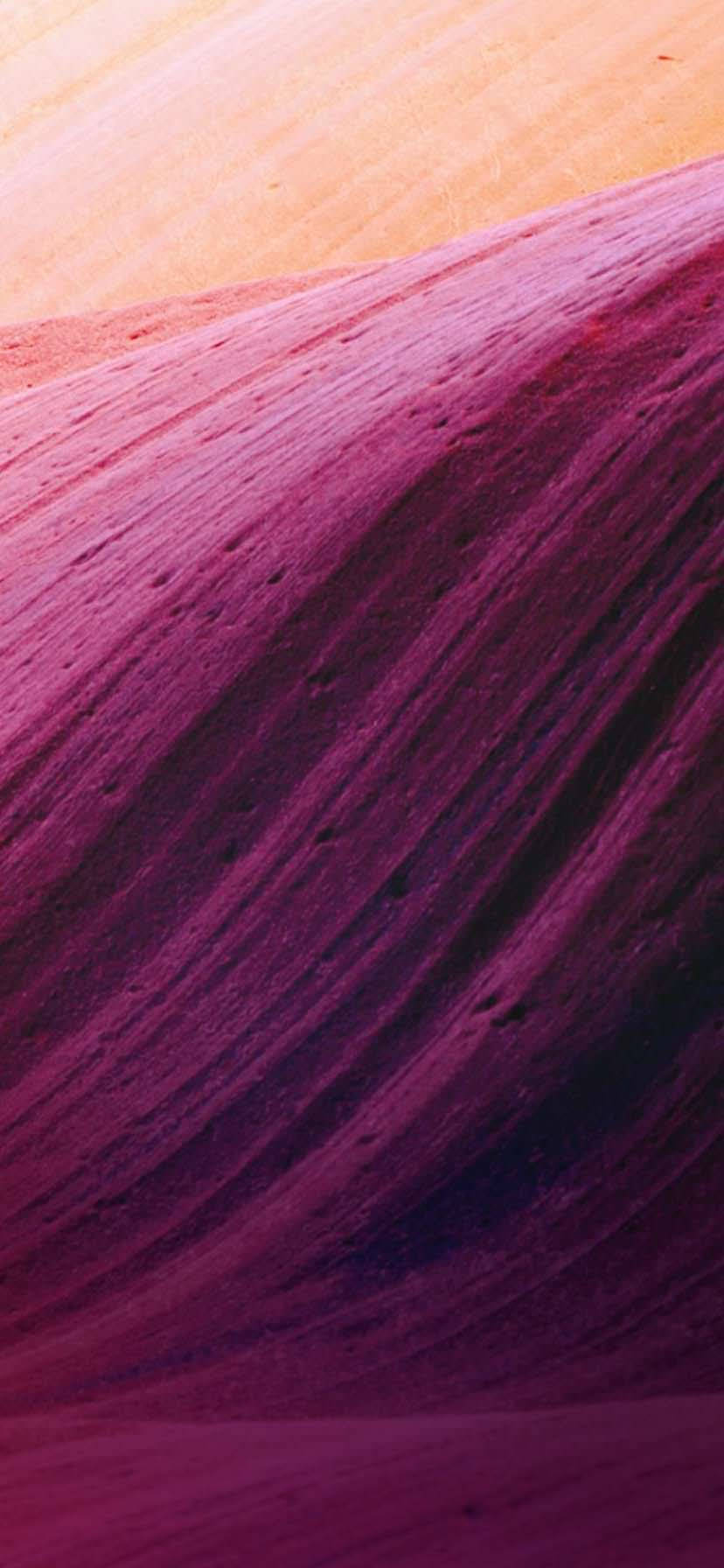 iPhone XR 米色紫色曲線 壁紙 — 鮮豔的洋紅色和蜜桃色層狀岩層的特寫，帶有紋理條紋。