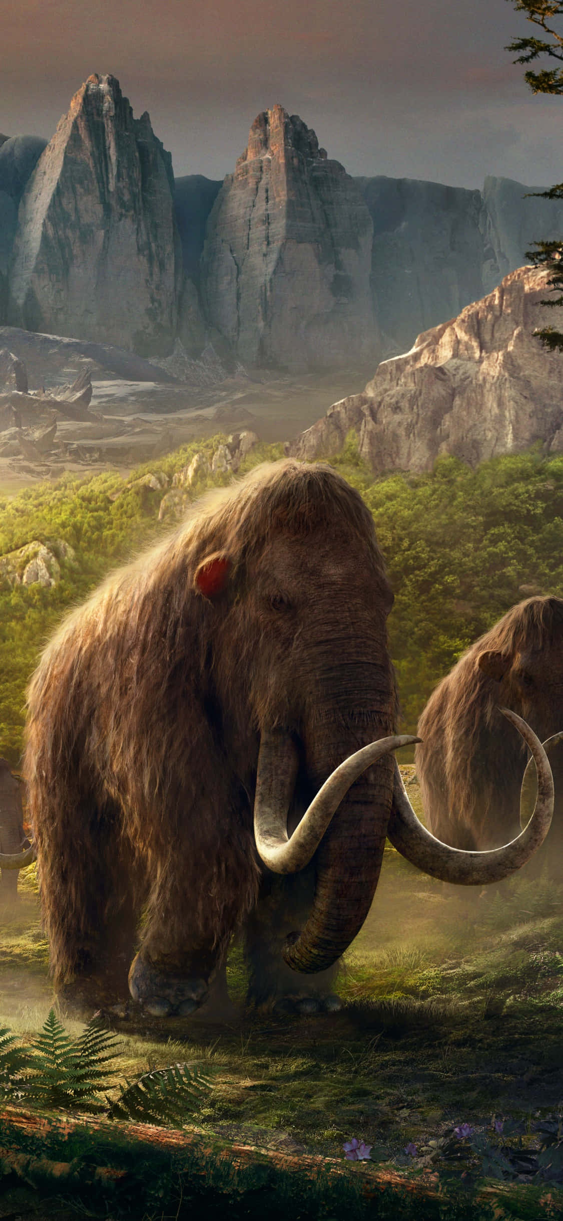 在 iPhone Xs 上體驗 Far Cry 4 的刺激 壁紙 — 一隻長毛猛獁象站在霧氣瀰漫的史前山谷中，周圍是高聳的懸崖和茂密的綠植，天空是柔和的黎明色調。