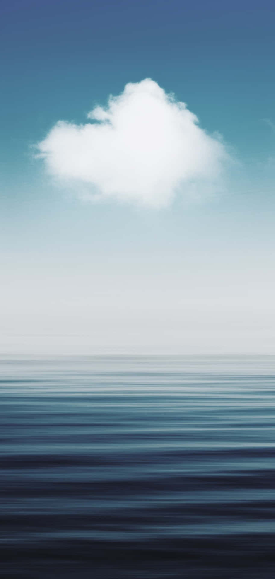 一朵雲在晴朗的藍天下漂浮在平靜的海面上。