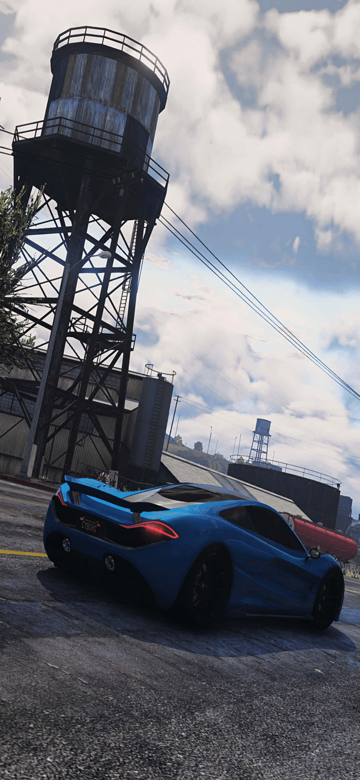 iPhone XS Max《GTA V》藍色跑車壁紙 壁紙 — 一輛充滿活力的藍色跑車停在多雲的天空下，旁邊是一個生鏽的工業水塔。