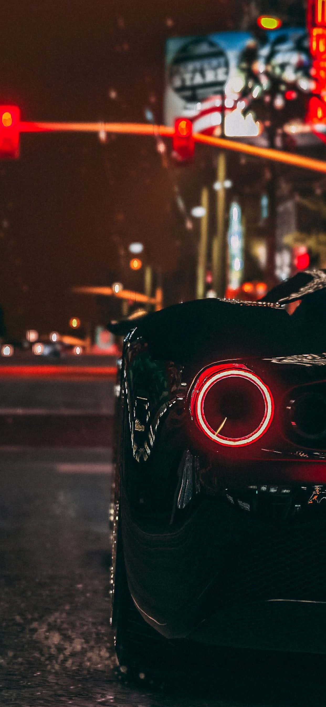 iPhone XS Max《GTA V》黑色汽車交通燈背景 壁紙 — 一輛時尚黑色跑車的發光紅色圓形尾燈在夜晚城市街道上飄落的雪中閃耀。