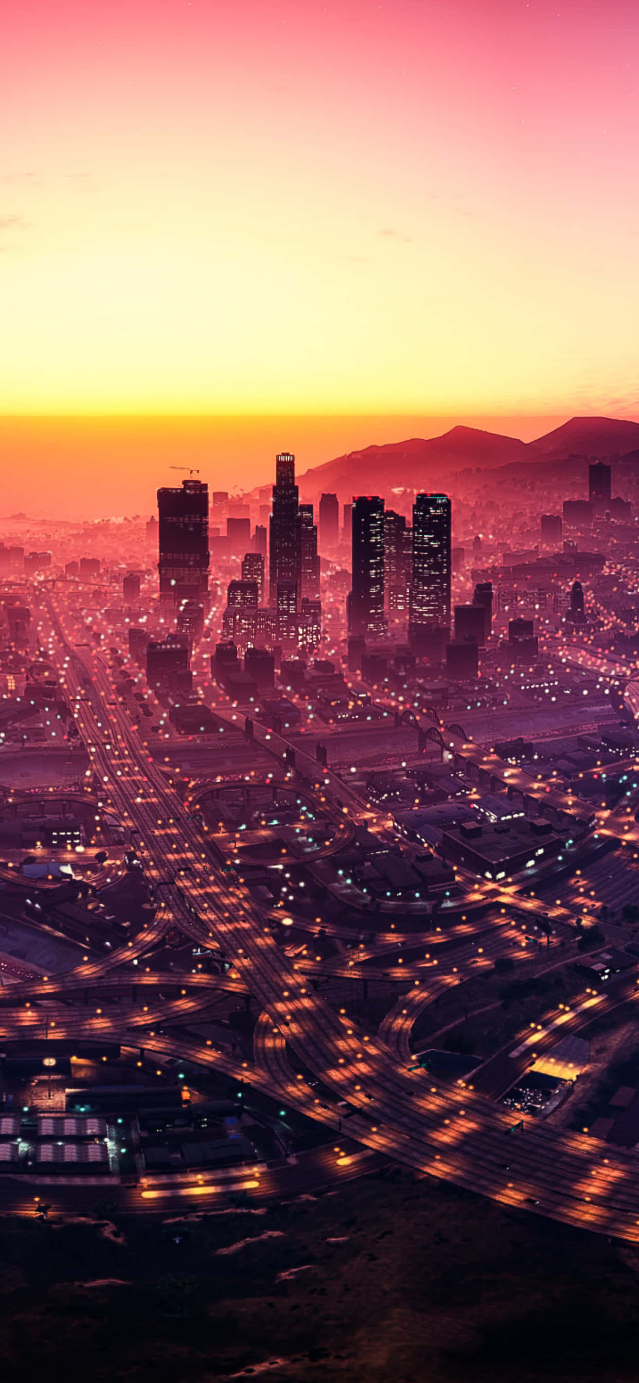 iPhone XS Max《GTA V》燈火輝煌的洛聖都夜景背景 壁紙 — 夕陽下廣闊城市的鳥瞰圖，發光的高速公路和摩天大樓在漸變的天空下。